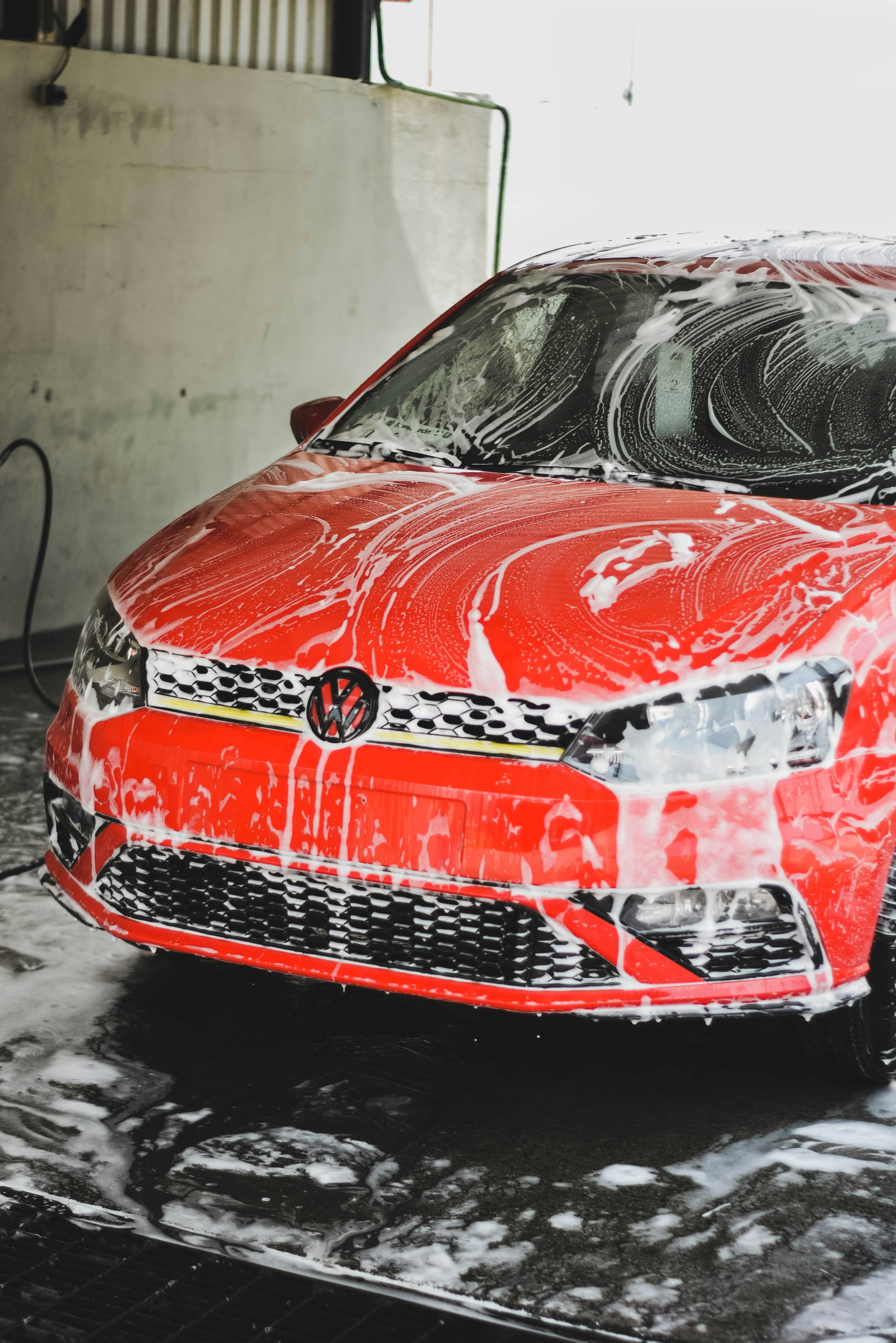 Professional Car Wash Service - Red car covered in soap foam